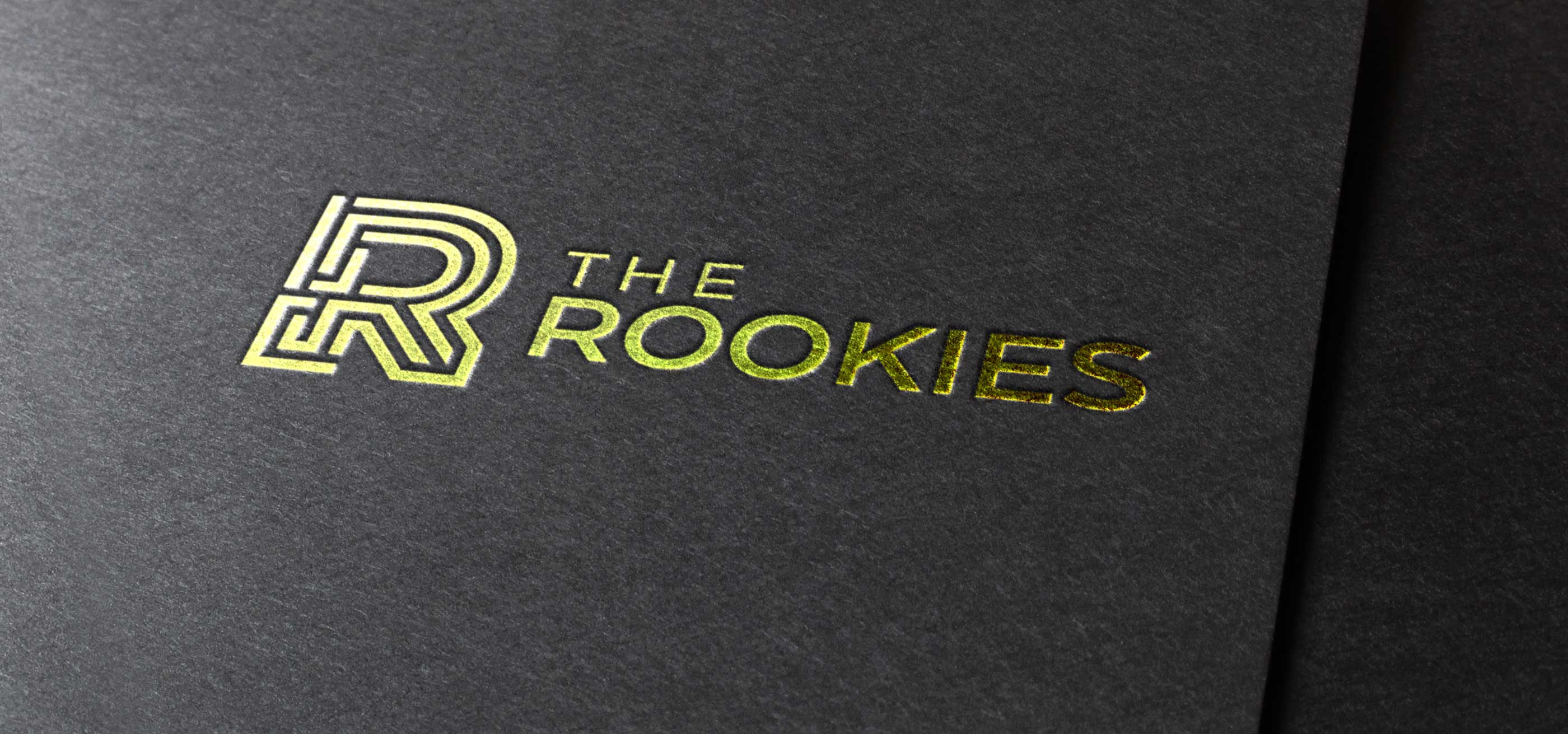 Logotipo dorado de ROOKIES estampado en pergamino negro