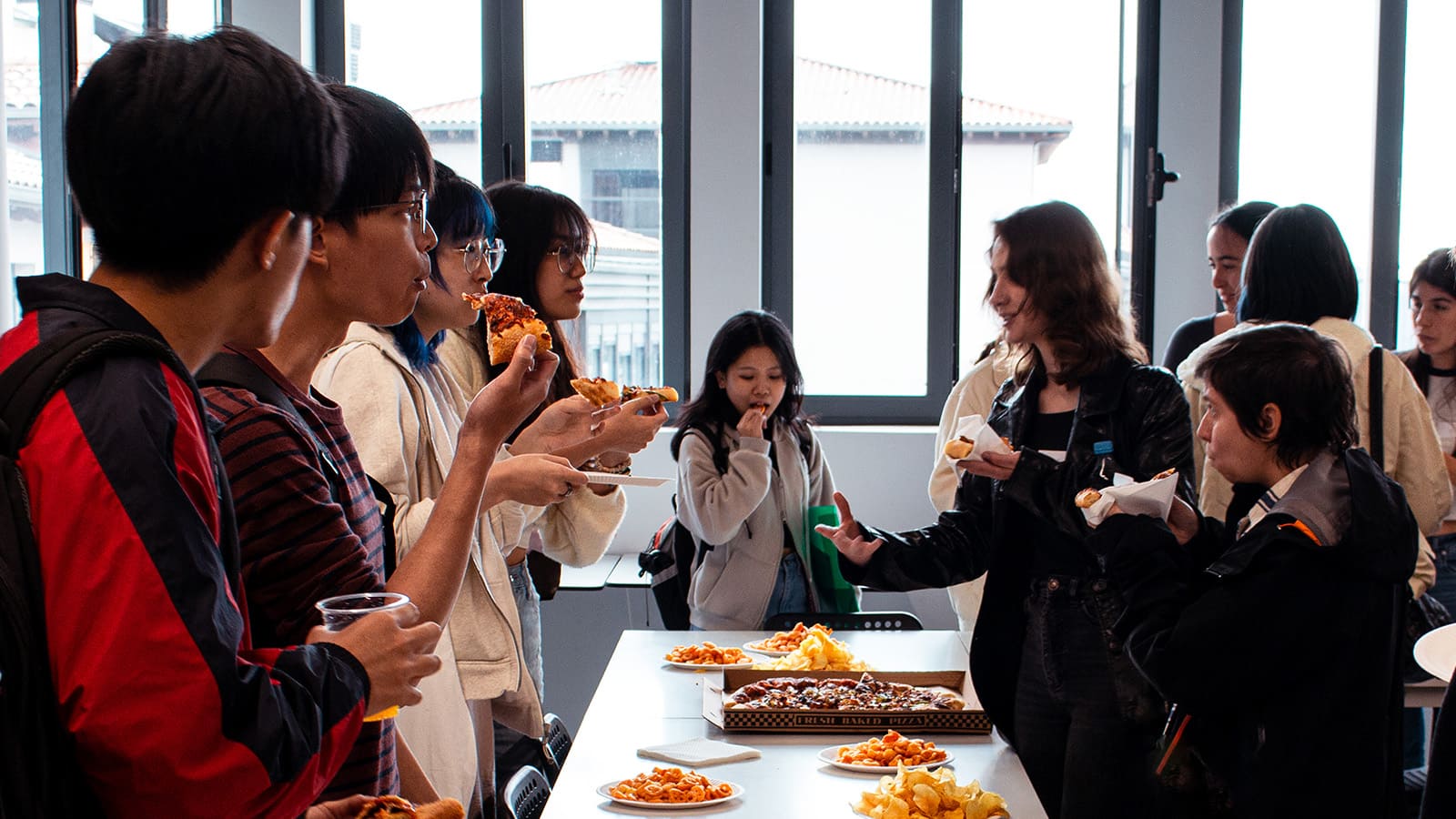 Los estudiantes anfitriones e invitados, comparten comida y bebida en el evento de bienvenida de DigiPen Europe-Bilbao.