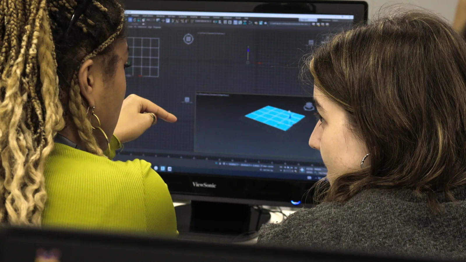 Estudiante pidiendo ayuda al profesor para su proyecto de animación 3D