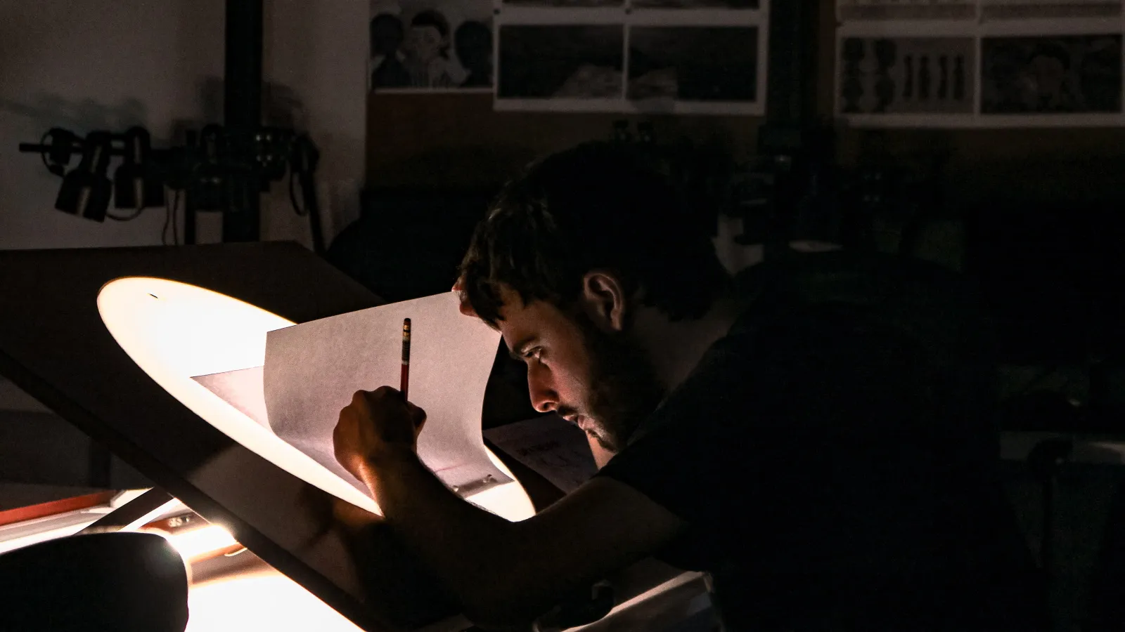 A boy overlaying animation frames on a lightbox
