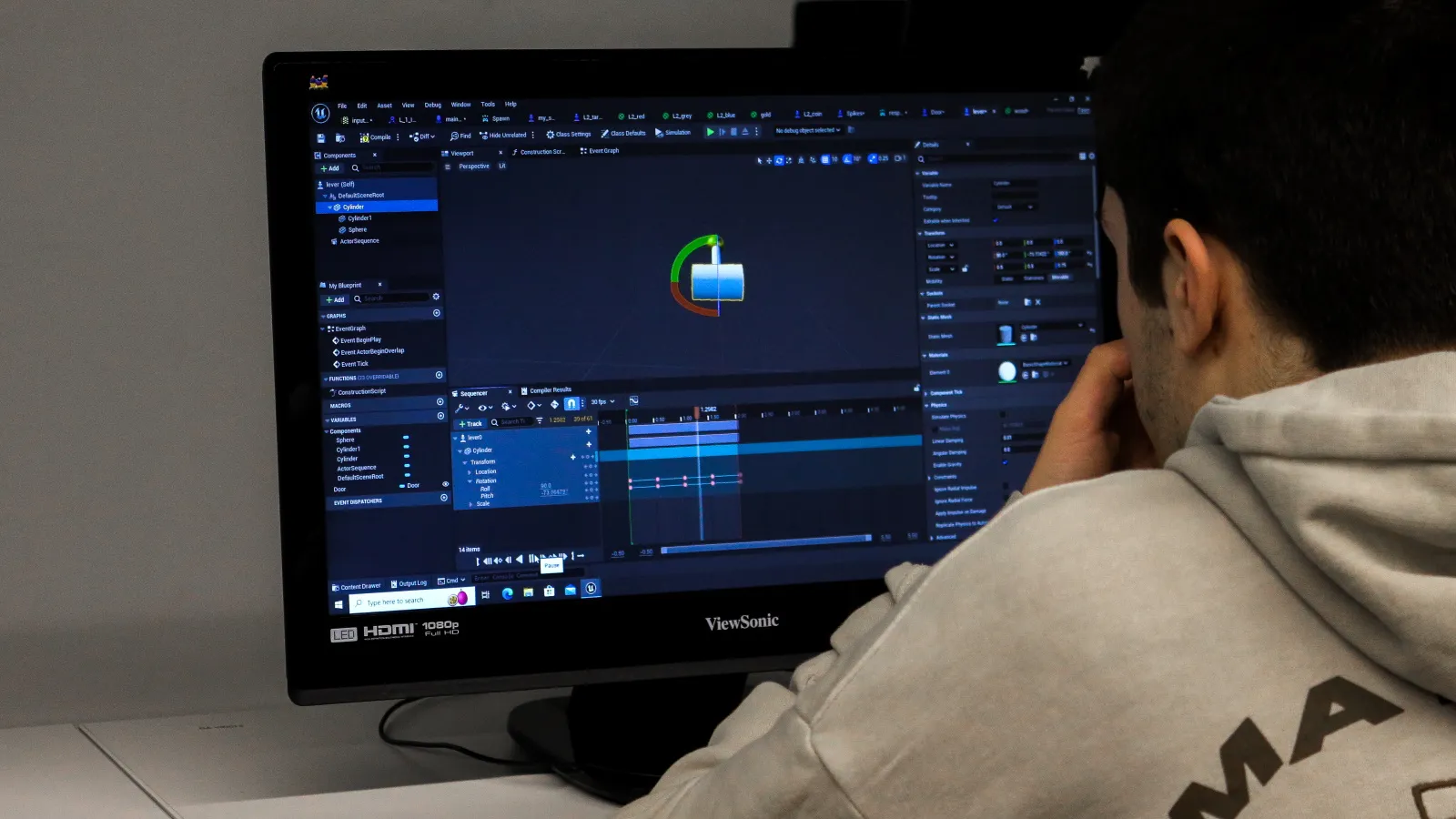 A student of the sumer workshops works on Unreal Engine editor. he is creating a cylinder and transforming it by rotating and scaling