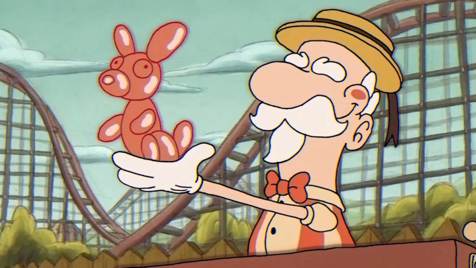 ﻿An old carnival balloonman holds up a red balloon dog ﻿at an amusement park with a roller coaster