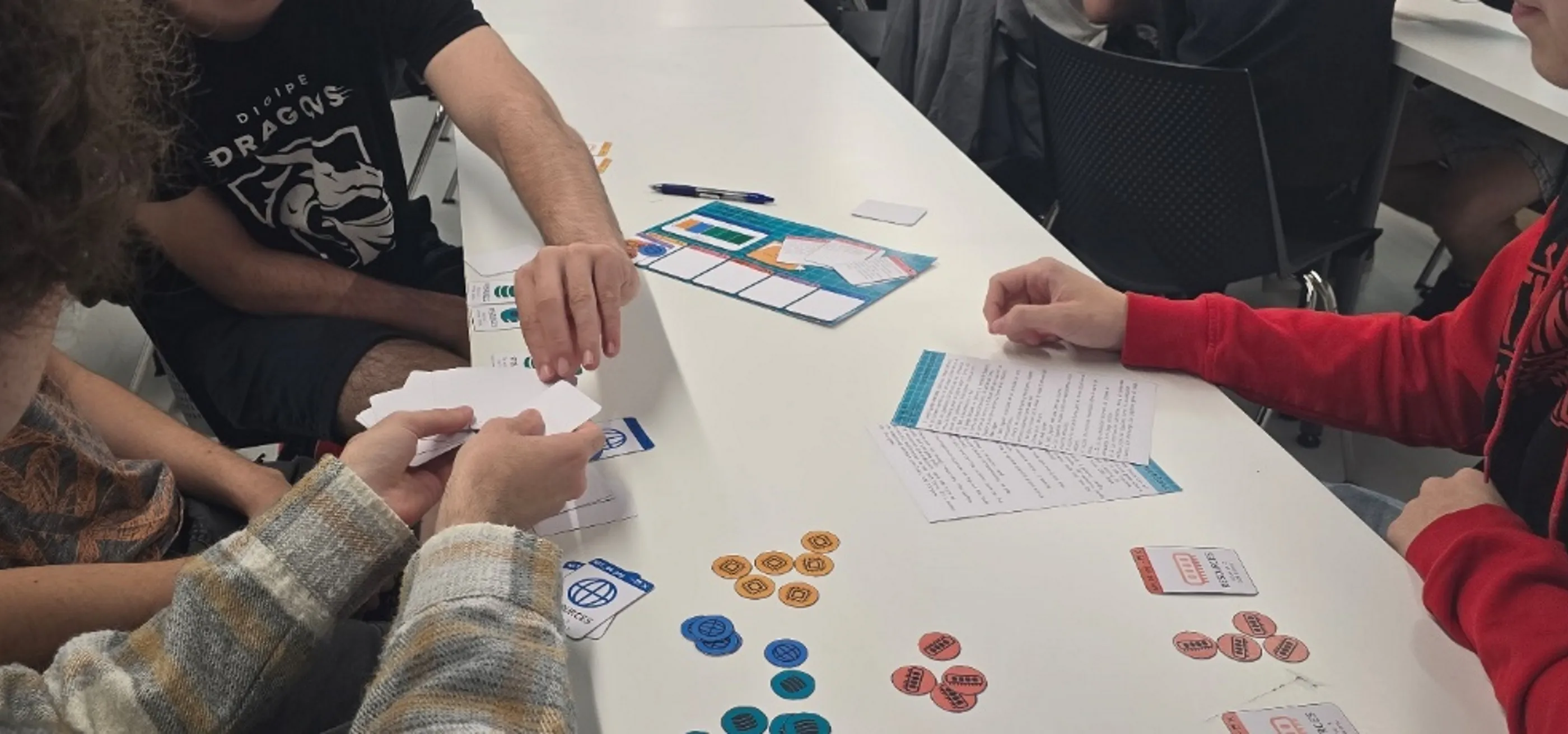 Four students playing ‘System Overload’ with cards in a DigiPen Europe-Bilbao’s table.