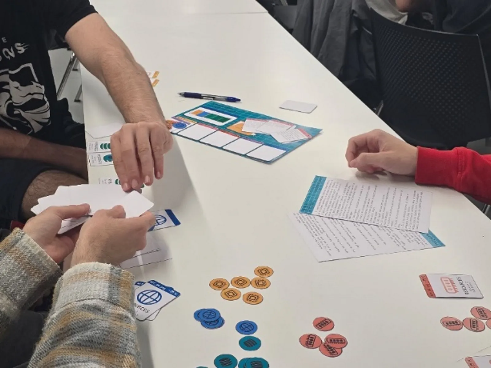 Four students playing ‘System Overload’ with cards in a DigiPen Europe-Bilbao’s table.