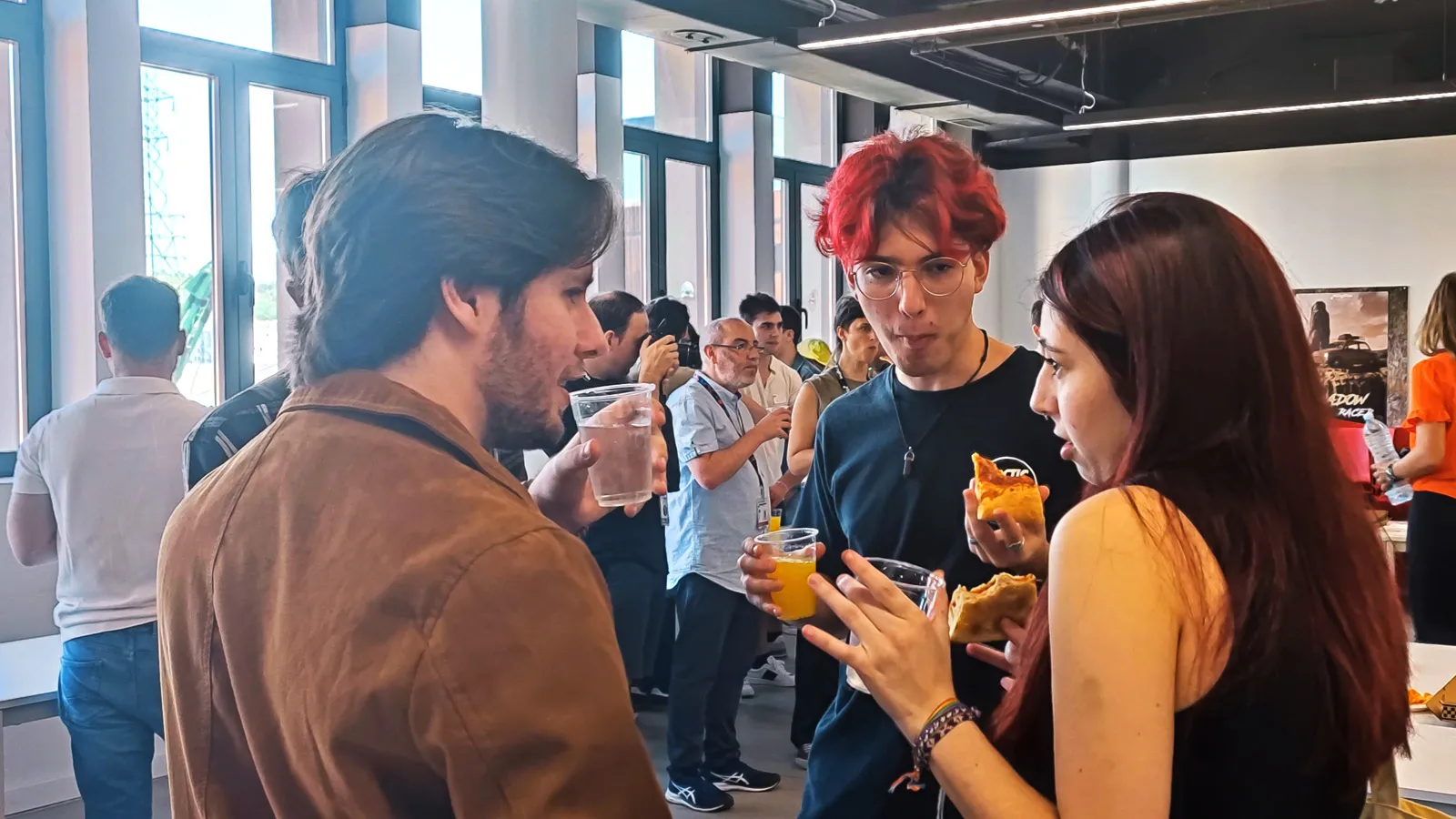 Freshman year students tasting pizza and chatting with their classmates.