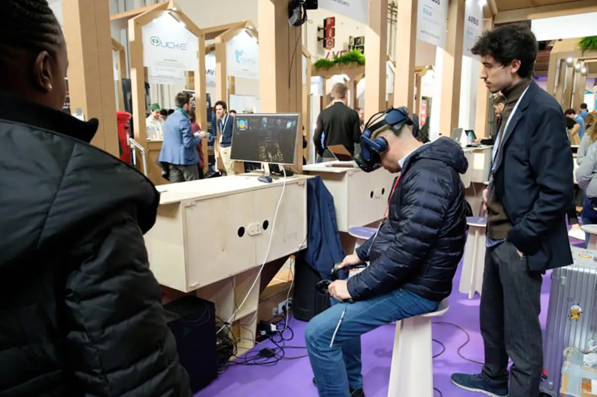 Ander Alzola observa en una conferencia a un cliente probando una demo de simulación de entrenamiento de vuelo de VRnam.