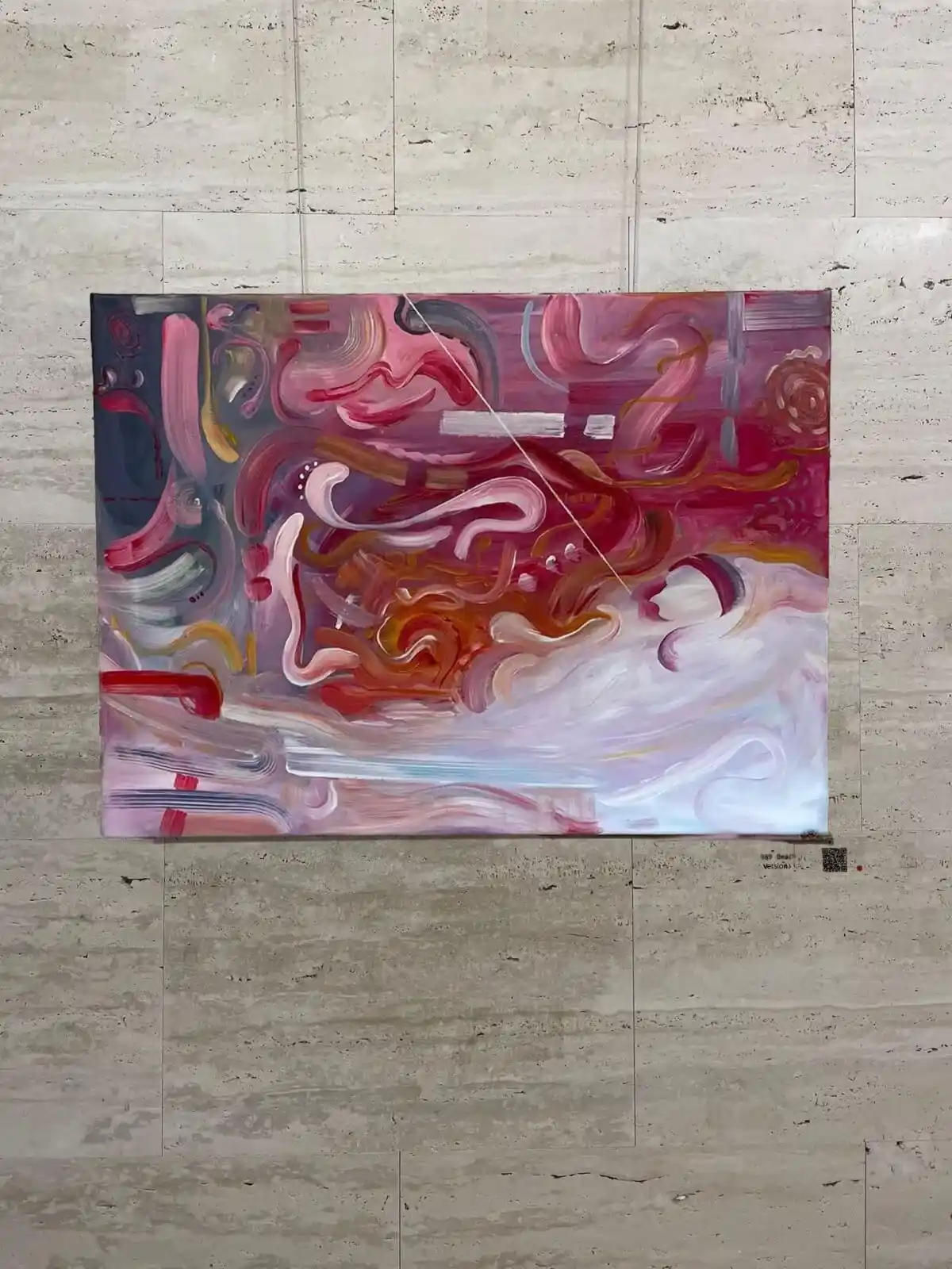 Abstract painting with red and pink swirling shapes on a stone wall