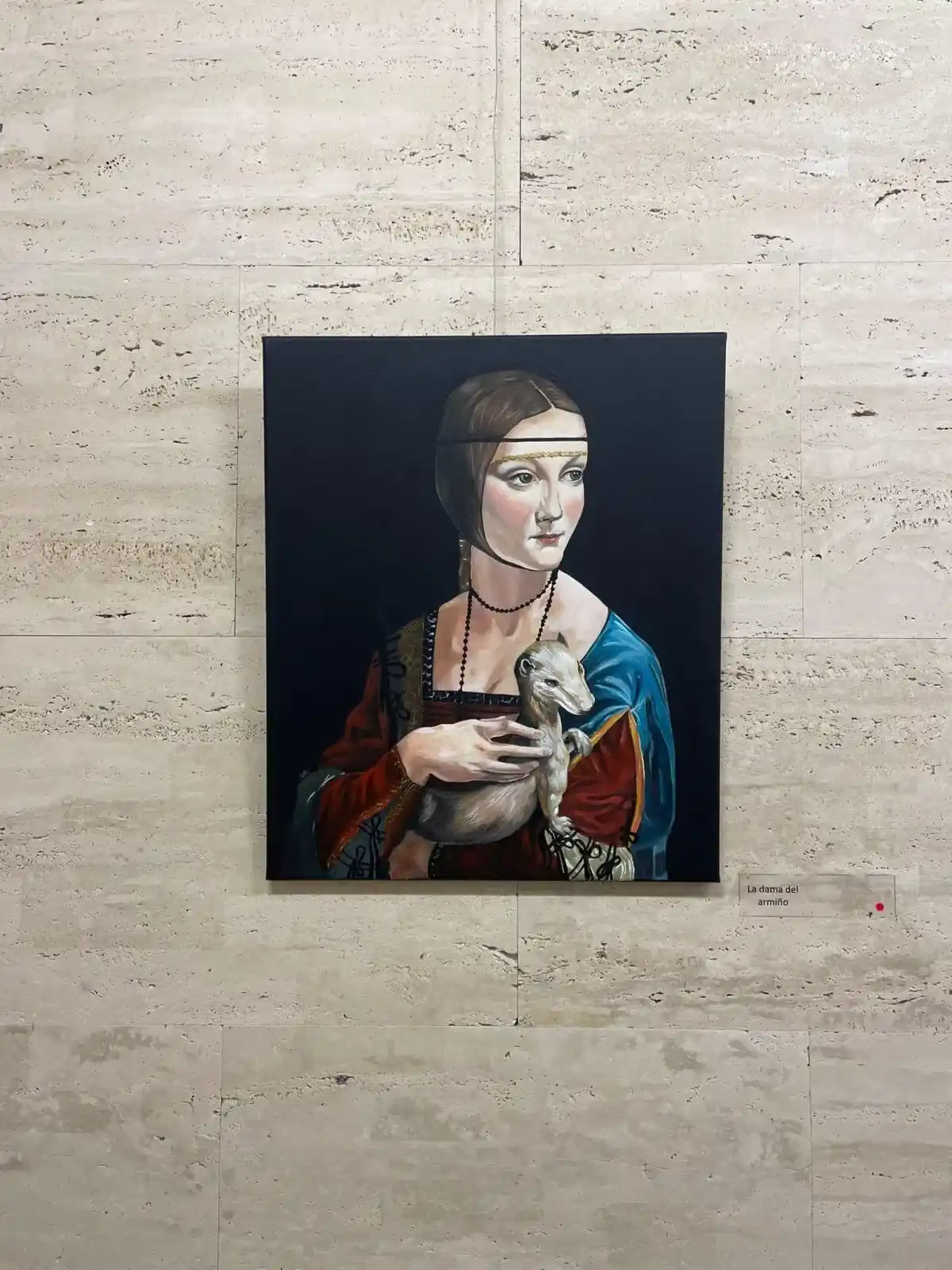 Una pintura representa un retrato de mujer en una pared de piedra.