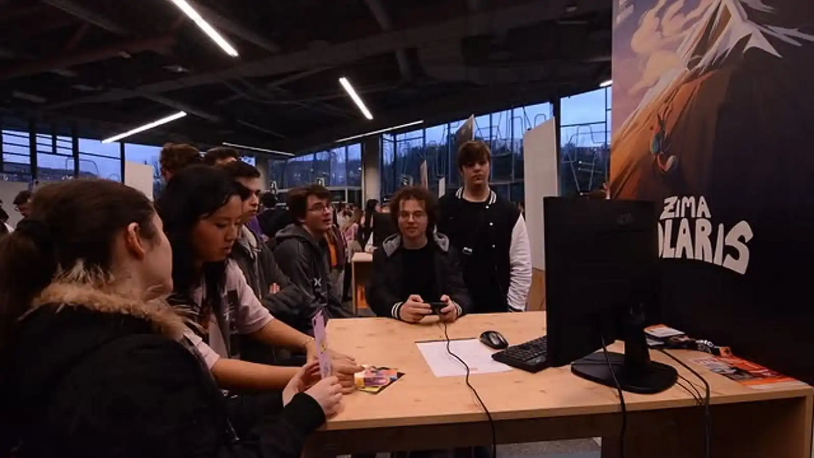 Estudiantes de DigiPen mostrando y jugando su juego 'Zima Polaris' en su stand durante la BIG Conference 2024.