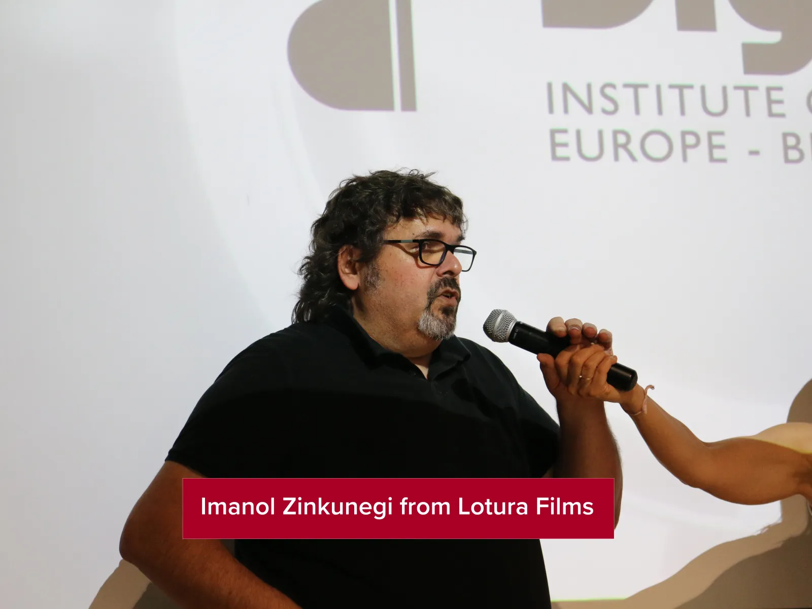 Imanol Zinkunegi from Lotura Films, speaking about the company with a projector behind