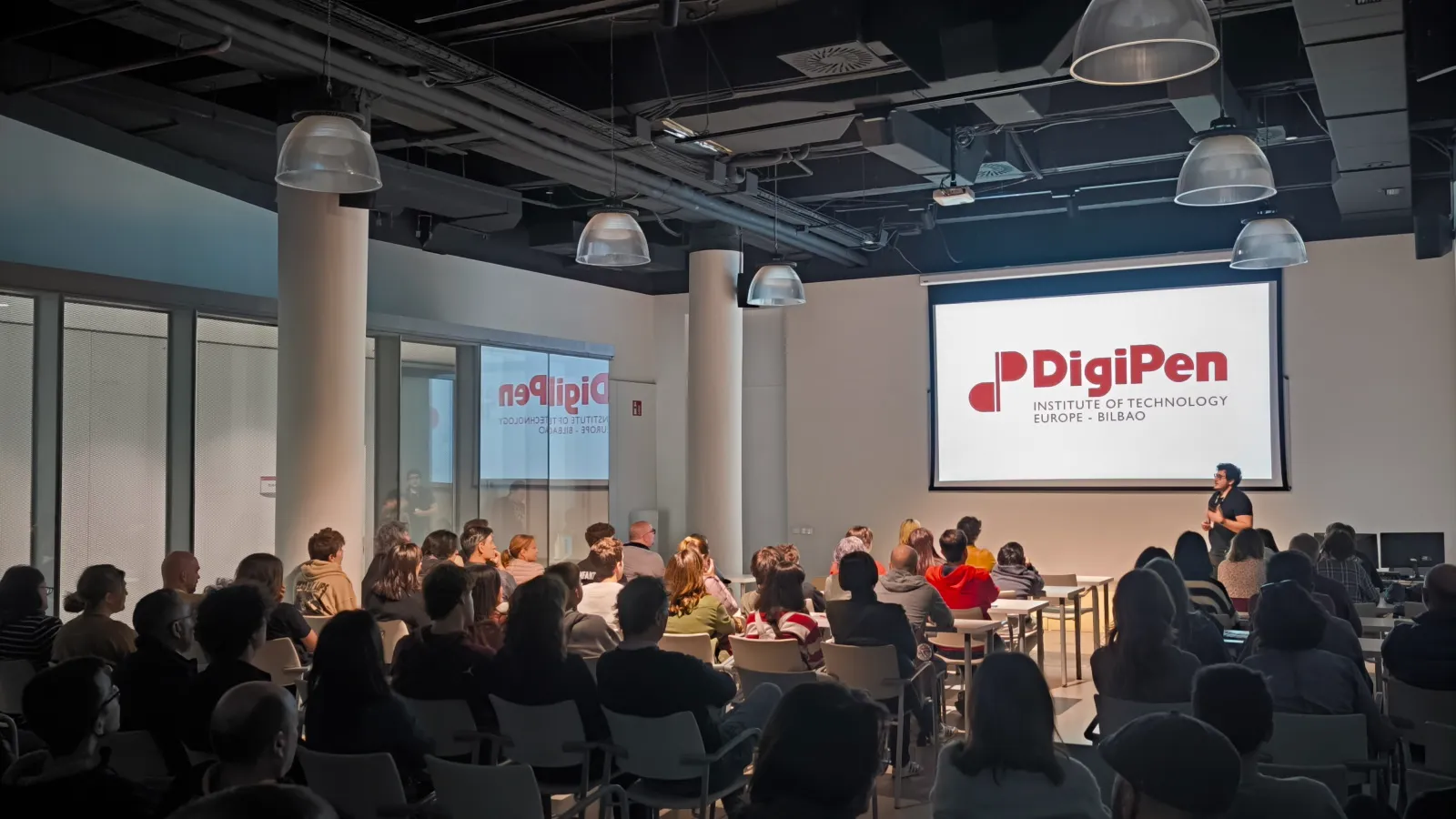 Attendees at DigiPen Europe-Bilbao's Open House 2023 event watching a presentation.