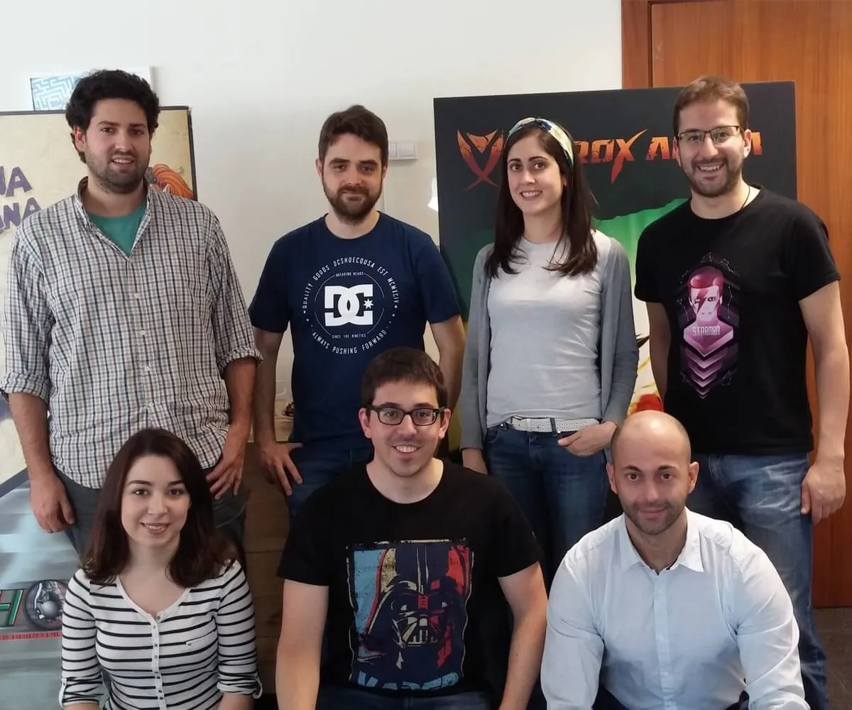 El equipo de Binary Soul posando frente a carteles que representan personajes de sus juegos.