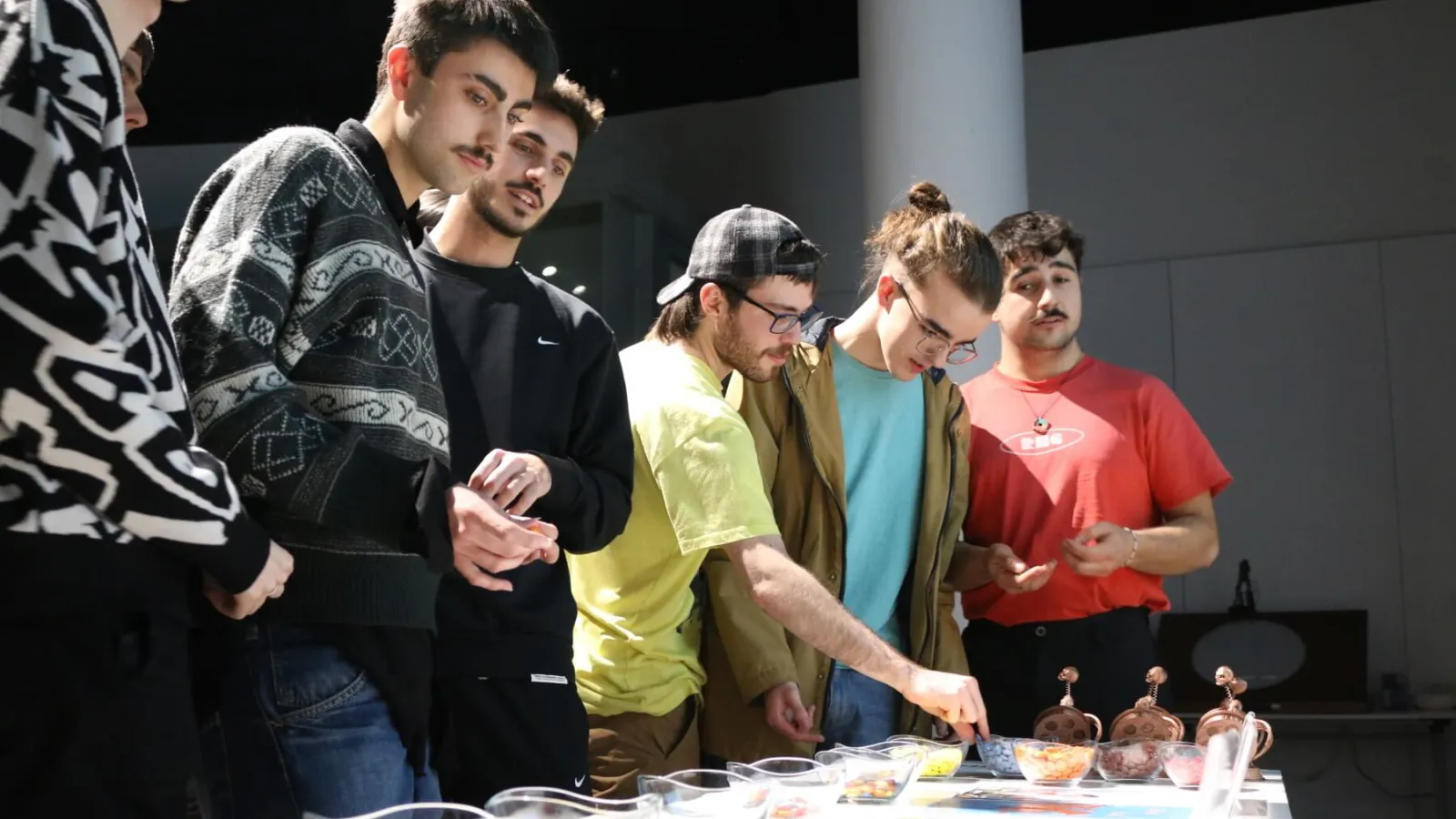 A group of students view a selection of posters depicting various student film projects.