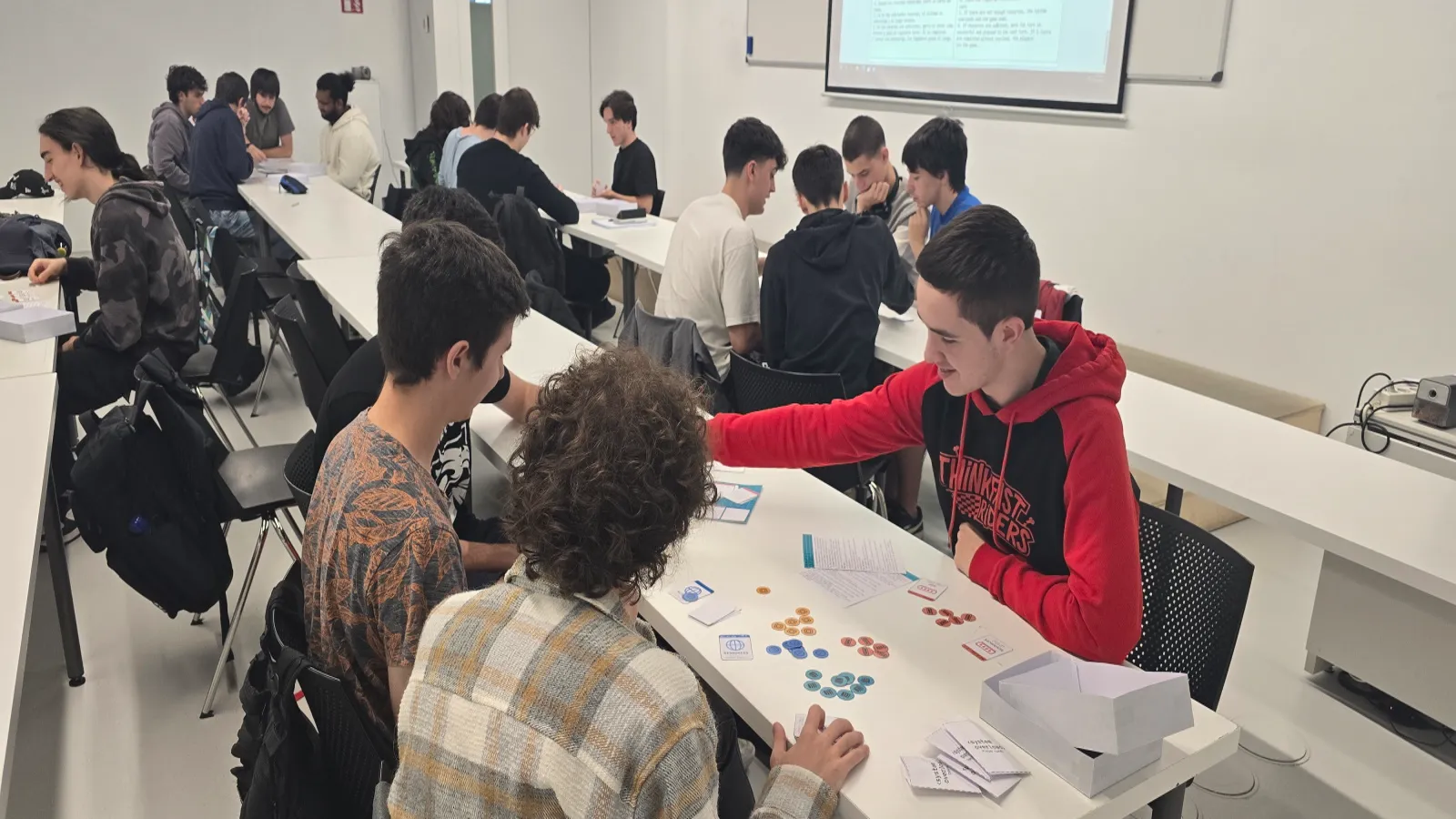 Four students playing ‘System Overload’ with cards at a classroom at DigiPen Europe-Bilbao.