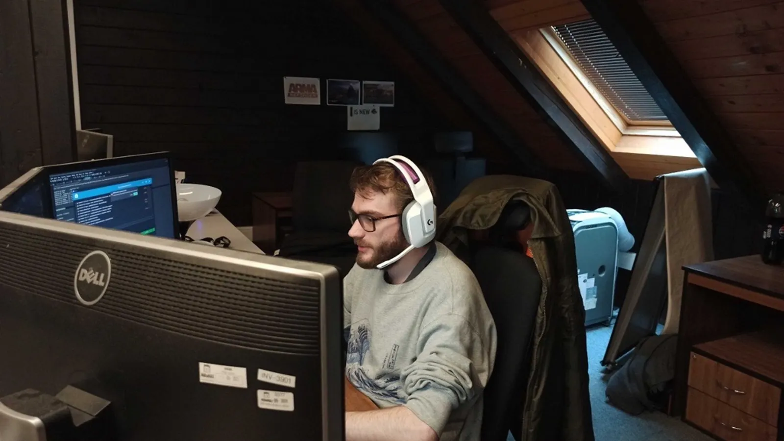 Jokin Bilbao working at his computer desk with a headset in the Bohemia Interactive office, focusing on his screen.