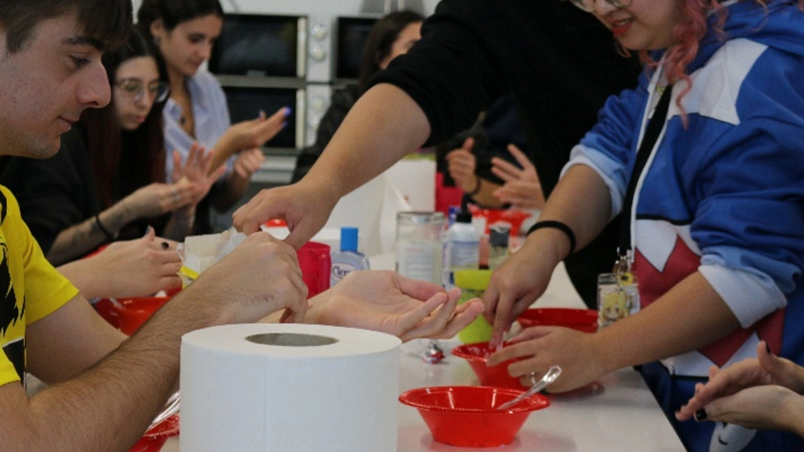 Students collaborating and practicing makeup techniques on each other during the Halloween Makeup Workshop.