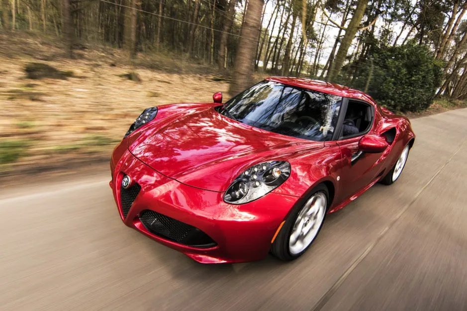 Sports car speeds alongside a wooded area